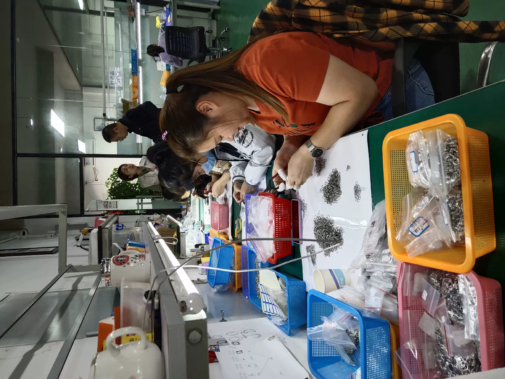 Workers assembling and checking jewelry components by hand